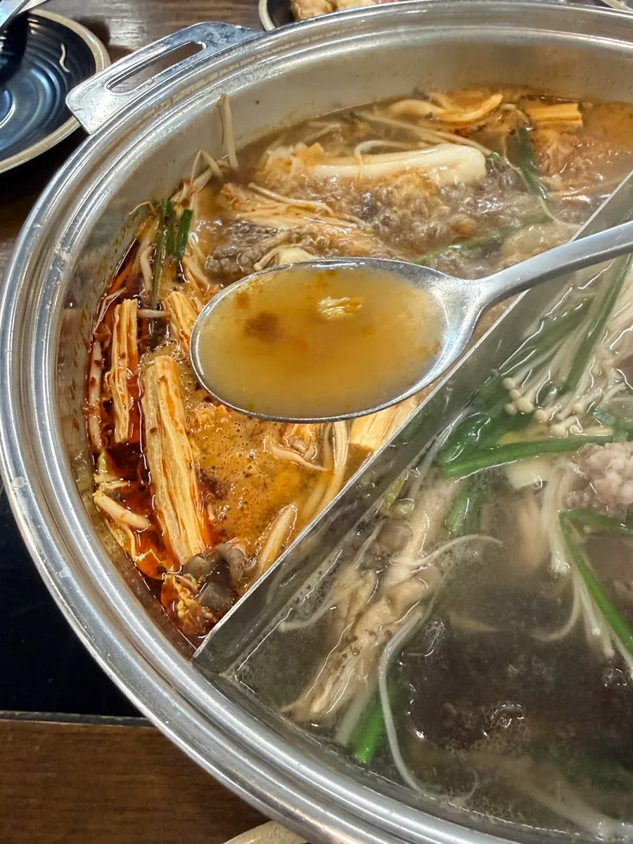 Meat cooking in the broth at the shabu-shabu table setting