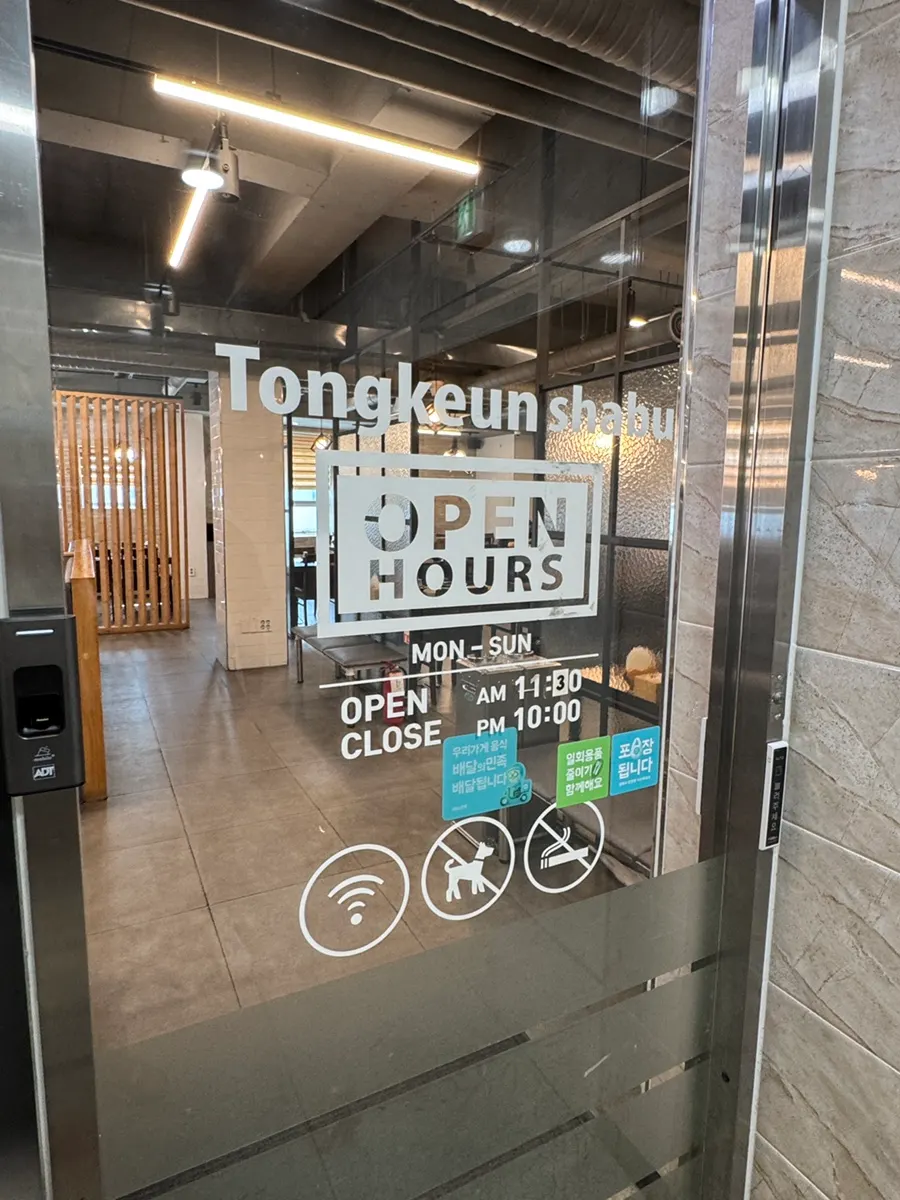 Price sign for Tongkeun Shabu at the building entrance