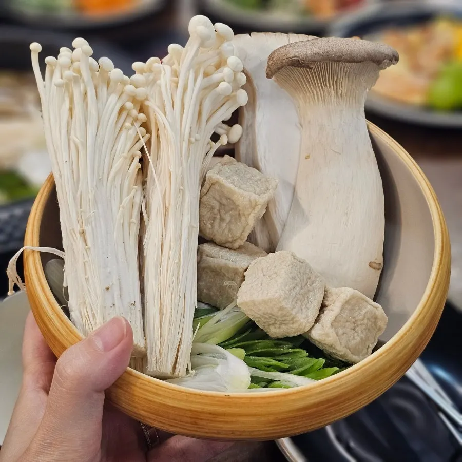 Table set with shabu-shabu ingredients and salad bar dishes