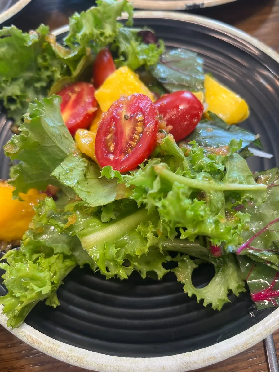 A plate of shabu vegetables and rice-paper-wrap ingredients