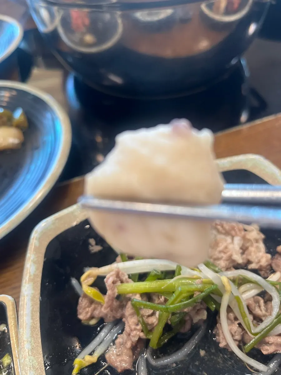 A piece of shabu-shabu meat dipped in sauce