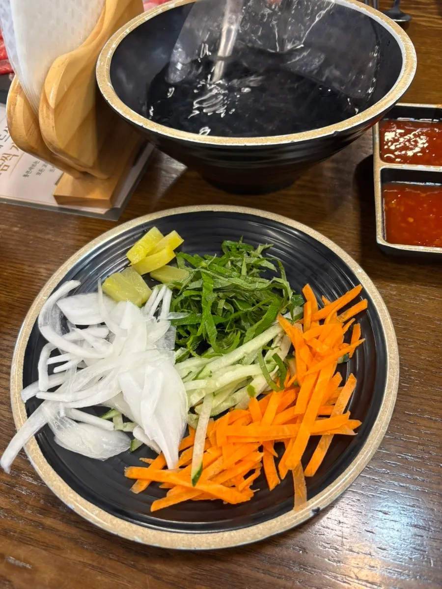 A bite of vegetables and meat cooked together in shabu-shabu