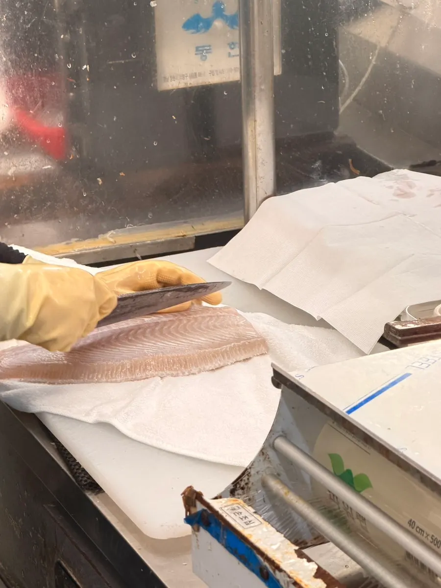 The owner's wife scooping the live fish from the tank