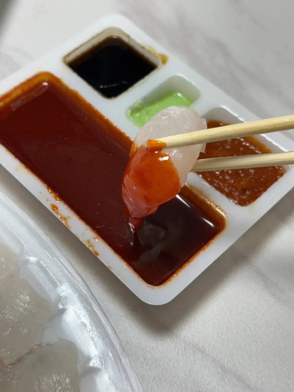 초장에 찍기 직전의 도톰한 광어회 한 점