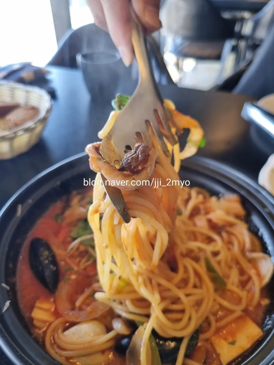 Scooping up the stone pot pasta broth with a spoon