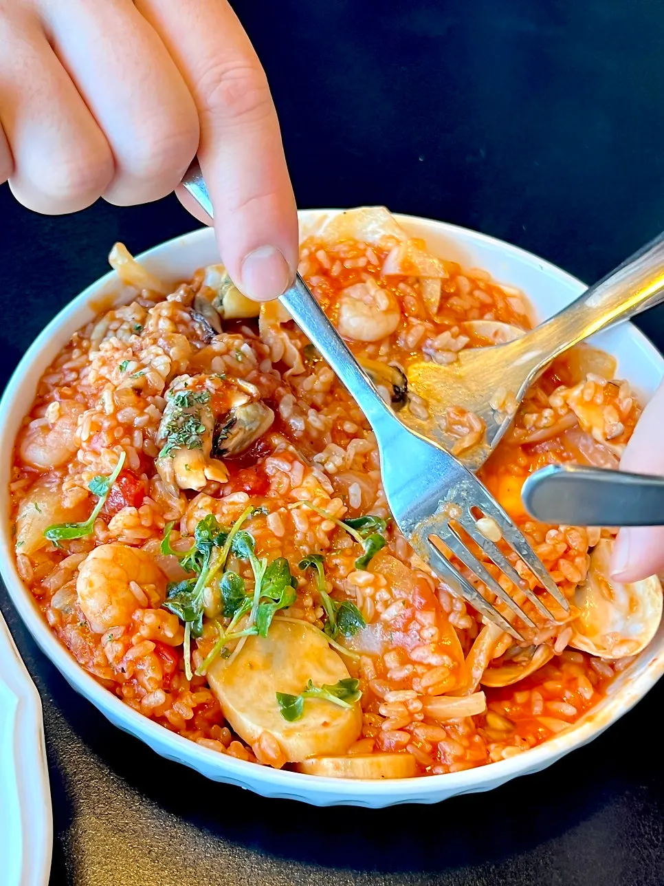 A spoonful of tomato risotto lifted from the bowl