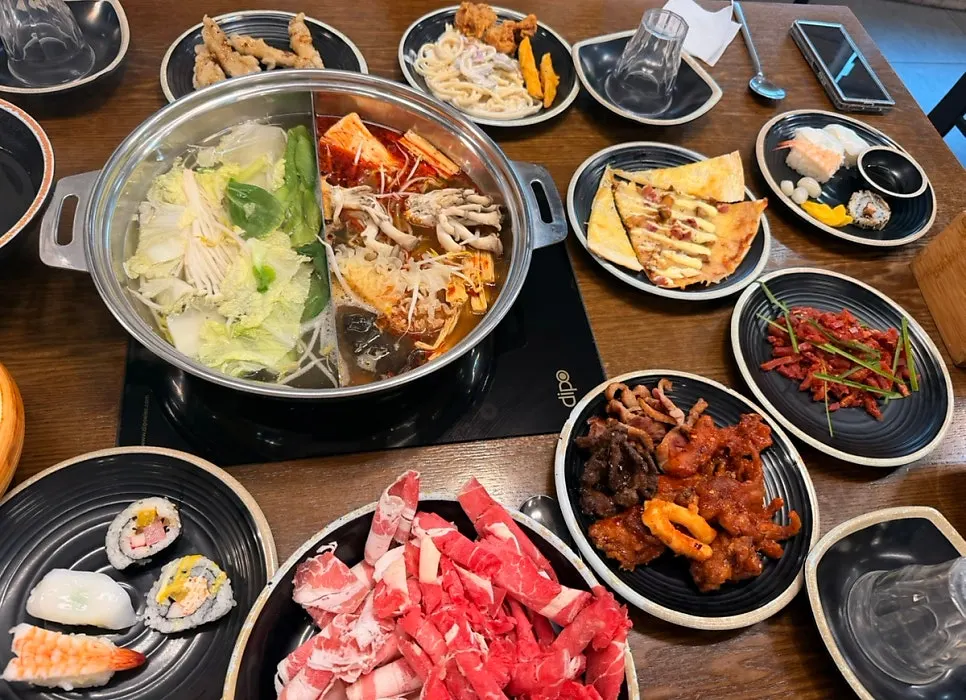 A full spread with the half-and-half broth and ingredients at Tongkeun Shabu