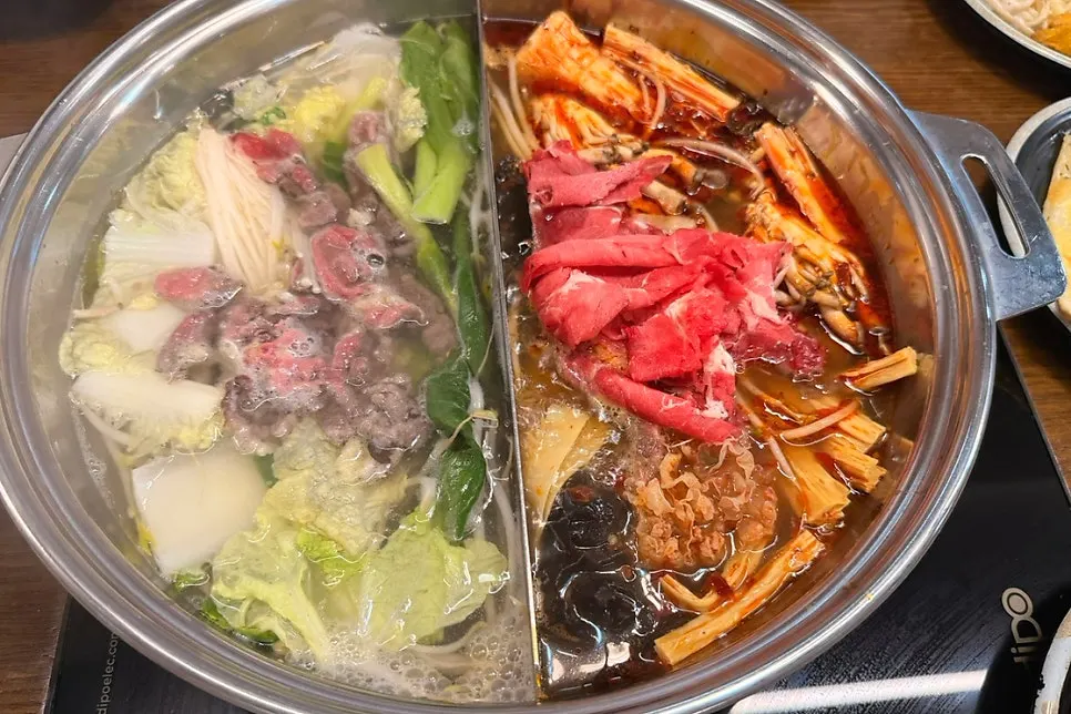 Dropping ingredients into the mala broth
