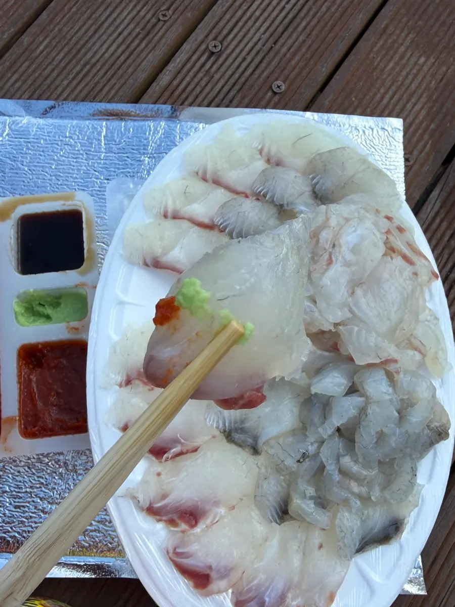 A meal of sashimi with cup noodles enjoyed in the park