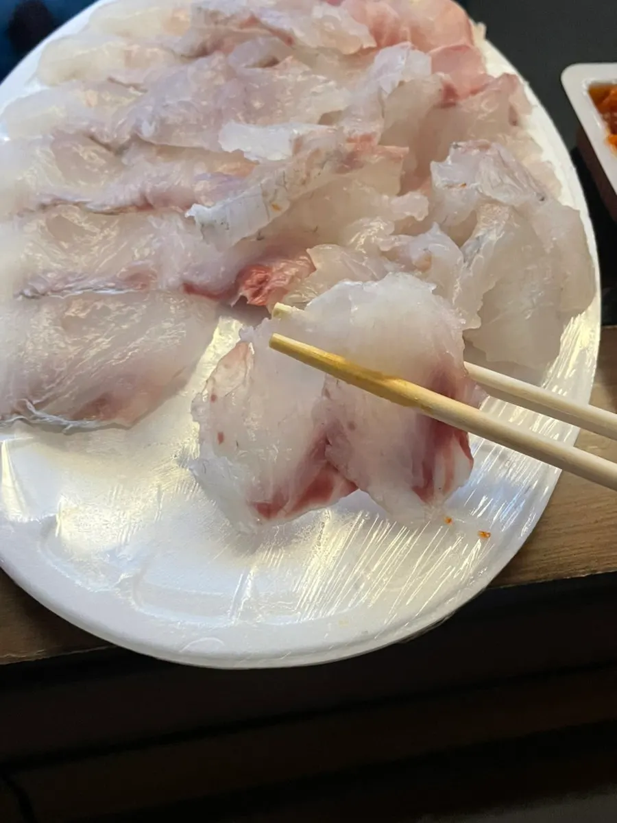 쫀득한 광어 회 한 점 집어 든 모습