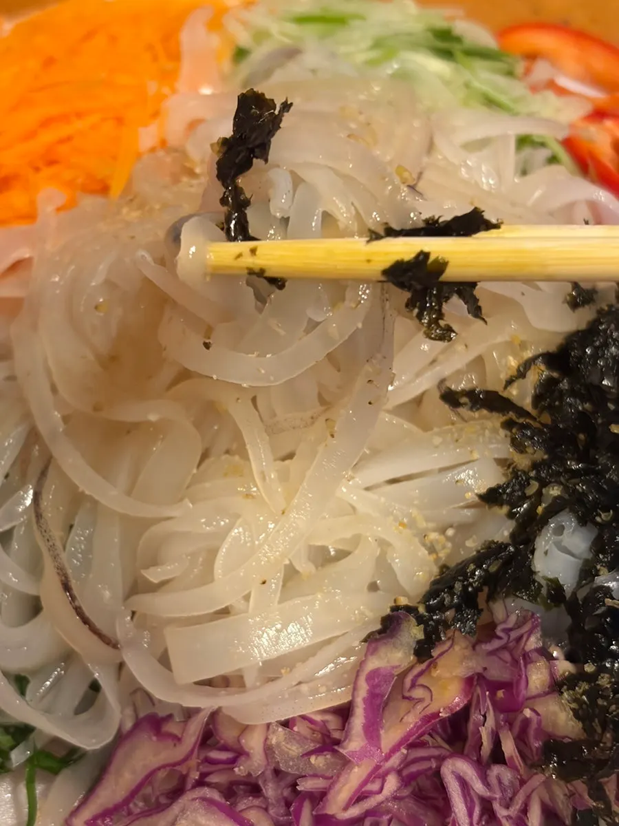 Cucumber, carrot, and cabbage packed alongside the sashimi