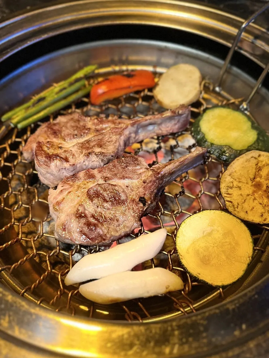 Lamb cooking through with sides alongside