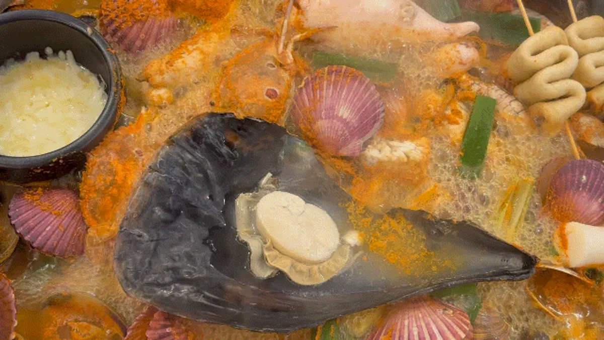 The lid opened on the clam hot pot at Gaetbeol-ui Jogae