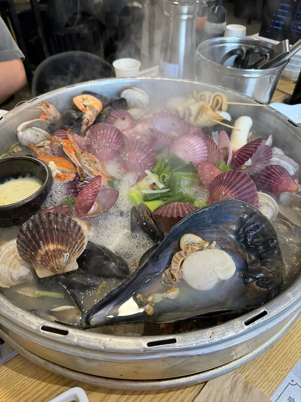 Giant clam hot pot simmering with lid on and a stopwatch