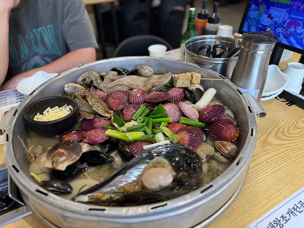 Steam rising from the clam hot pot as the lid is lifted