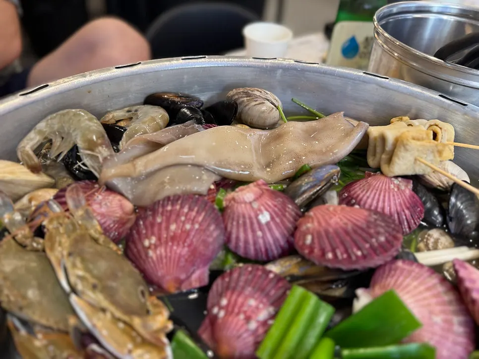 Staff member cleaning half-shell clam and squid