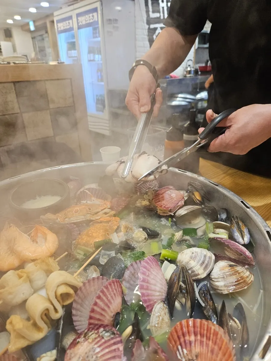 Hot pot filled with scallops, mussels and cockle