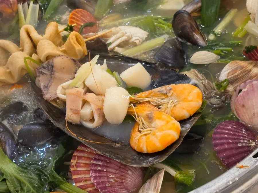 Clam hot pot topped with squid and mool-tteok