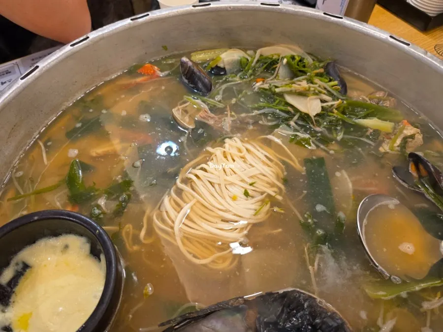 Kalguksu noodles added into the clam broth