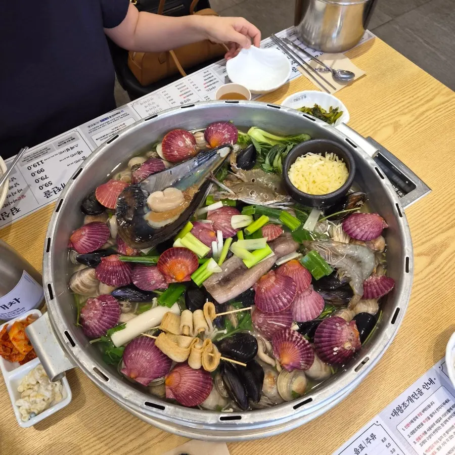 뚜껑을 덮은 조개전골 솥과 상차림