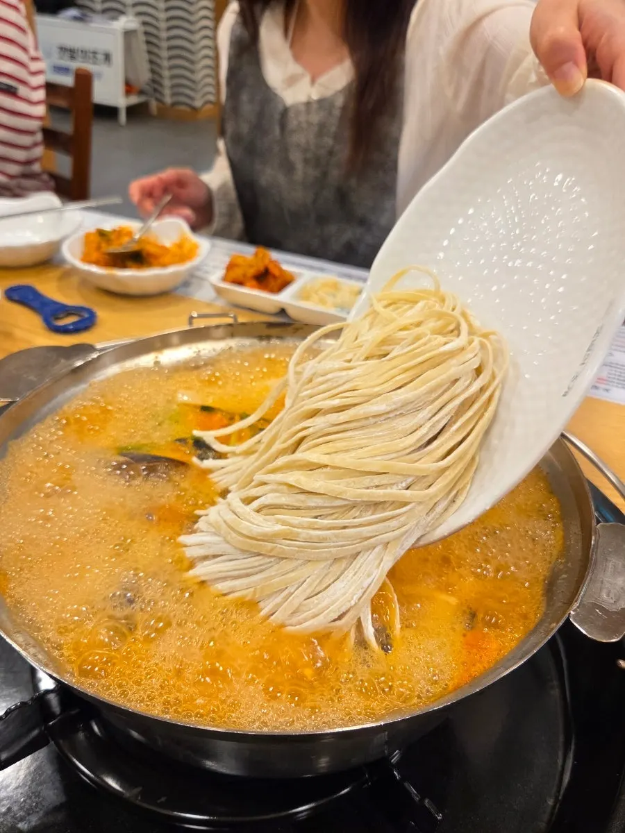 A bowl of spicy kalguksu with clam meat