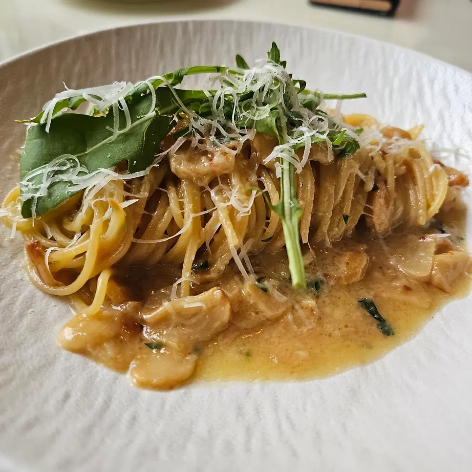 Aglio olio pasta topped with vegetables and cheese