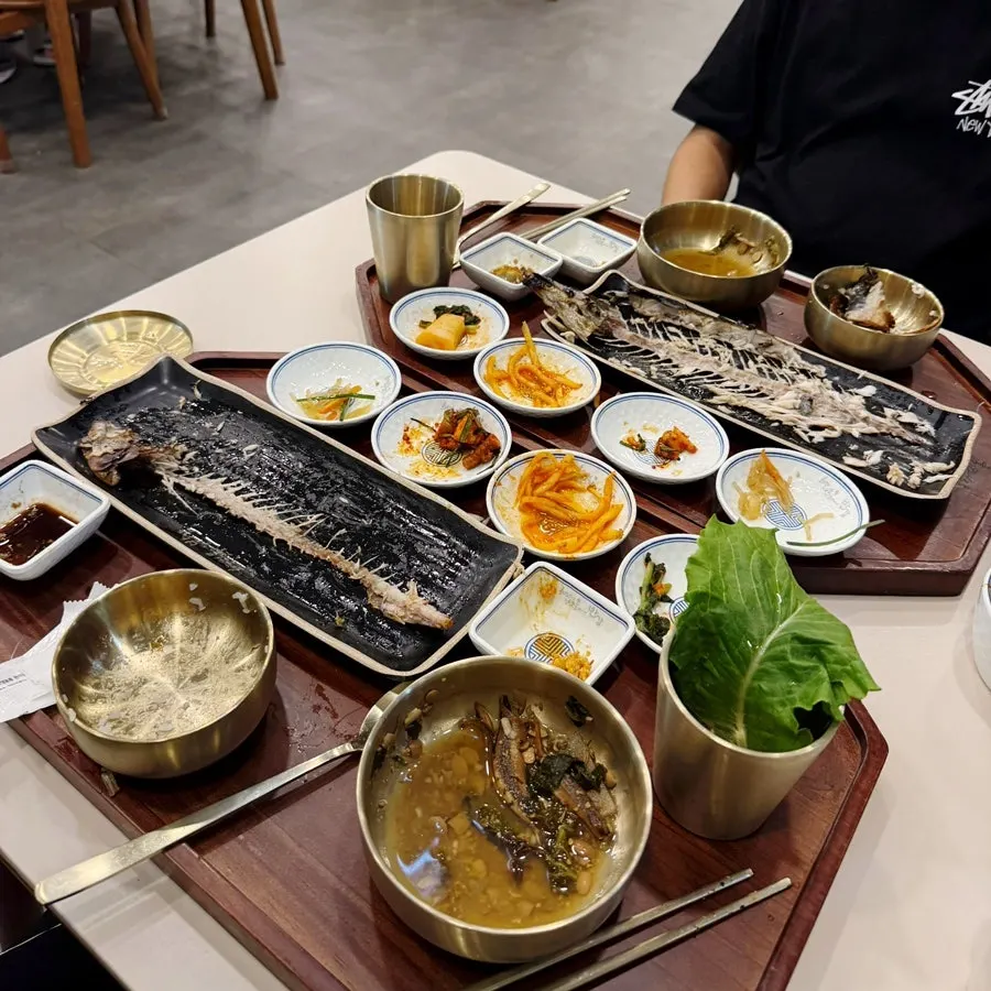 Two people eating the grilled fish sets together