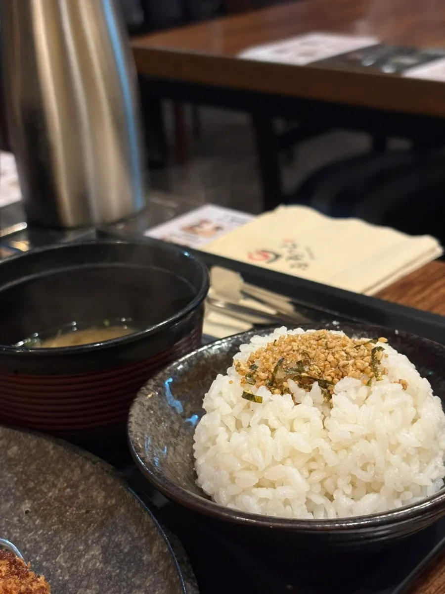 A piece of gyukatsu picked up with chopsticks