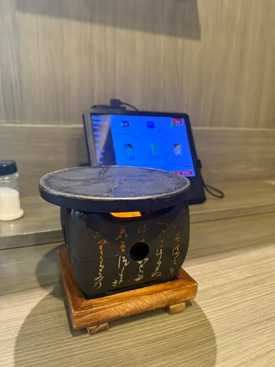 Mini charcoal grill placed on the table after ordering