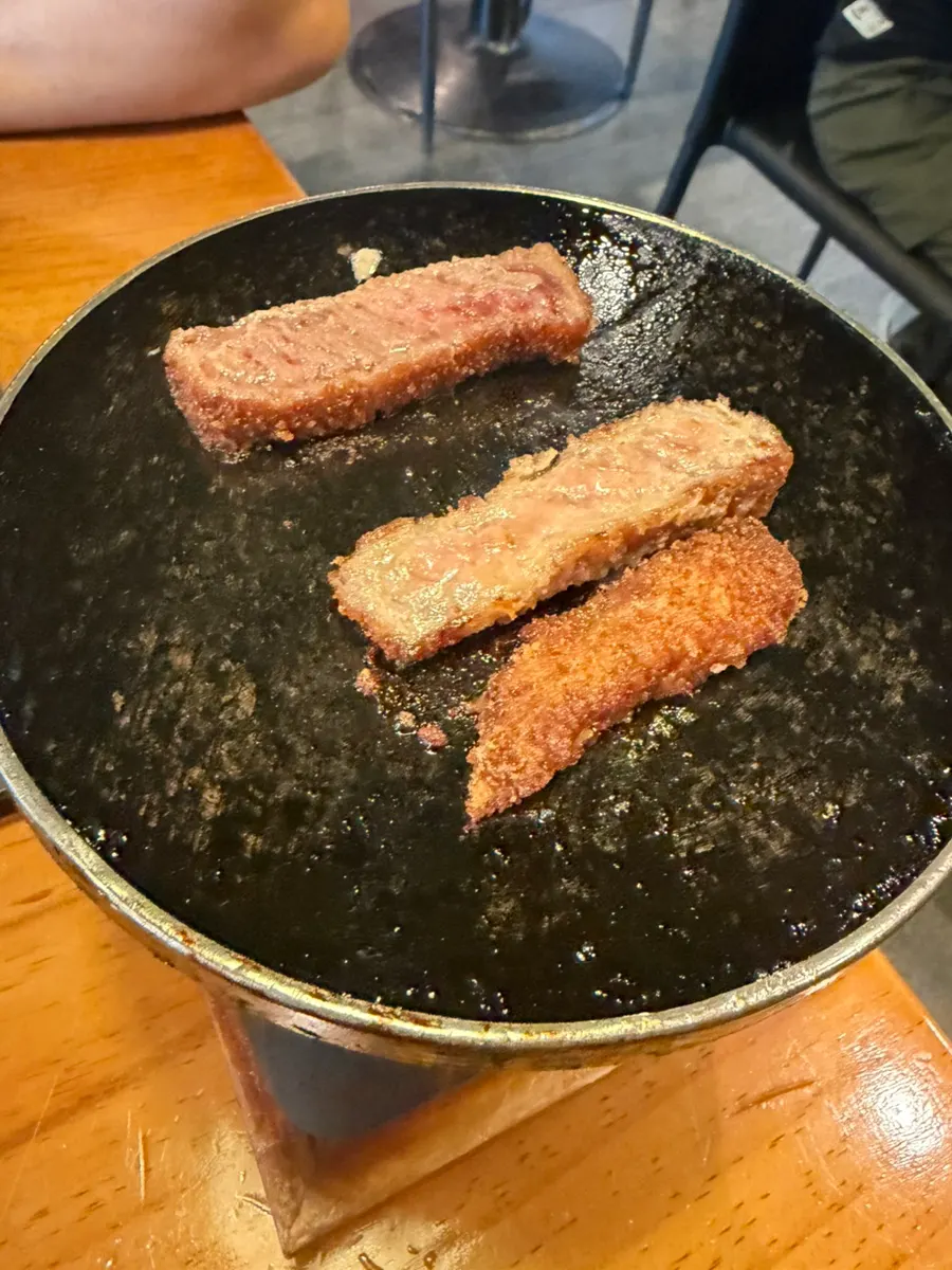 A piece of gyukatsu topped with fresh wasabi