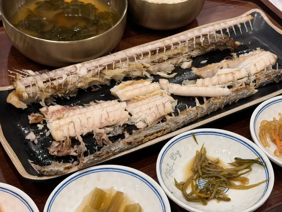 Picking the flesh off the grilled hairtail
