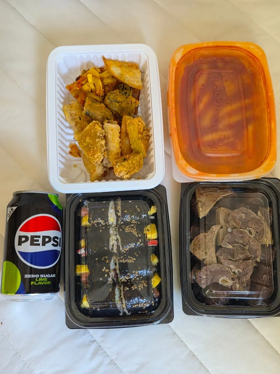Tteokbokki and fried snacks in takeout containers