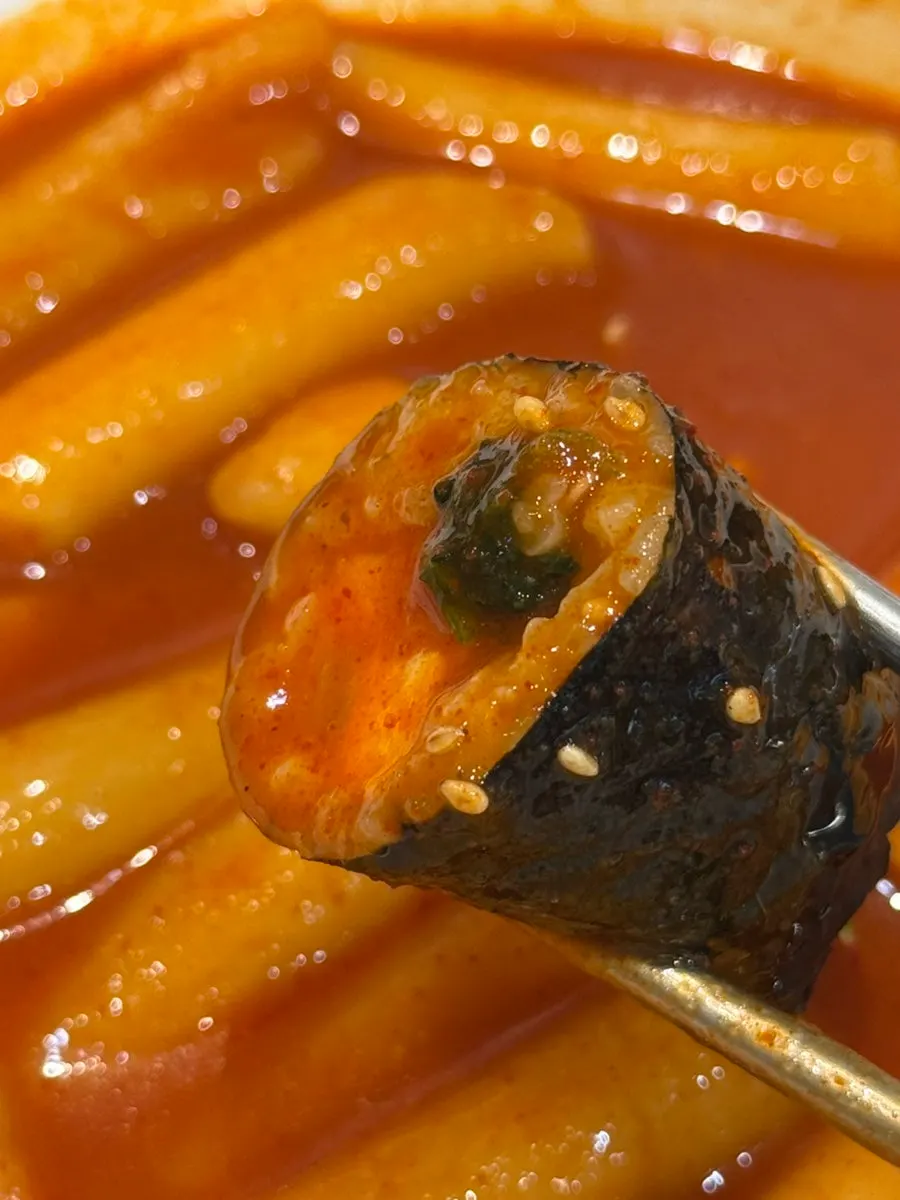 Mini gimbap dipped in tteokbokki broth