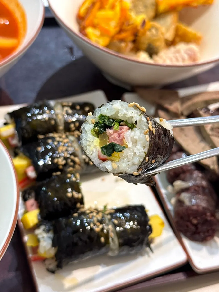 Mini gimbap dipped into tteokbokki broth
