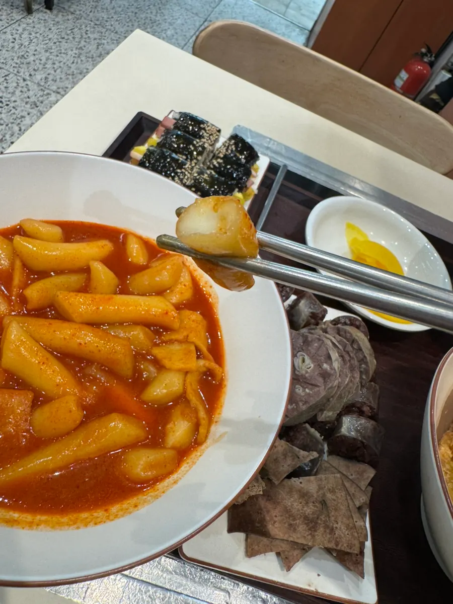 Picking up a piece of rice cake from the tteokbokki