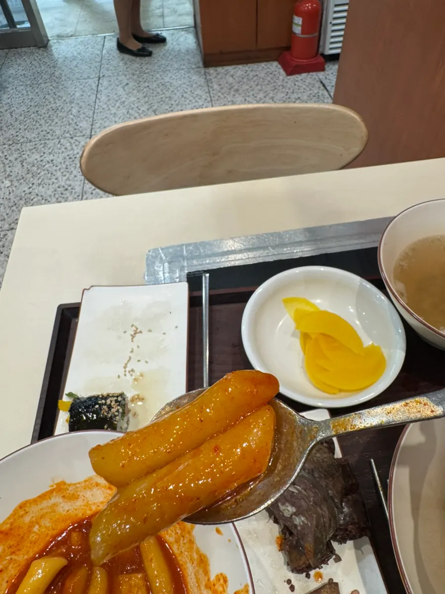 Picking up two rice cakes at a time from the tteokbokki