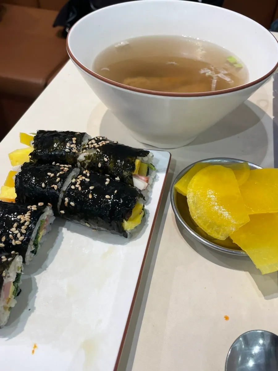 Mini gimbap dipped in tteokbokki sauce
