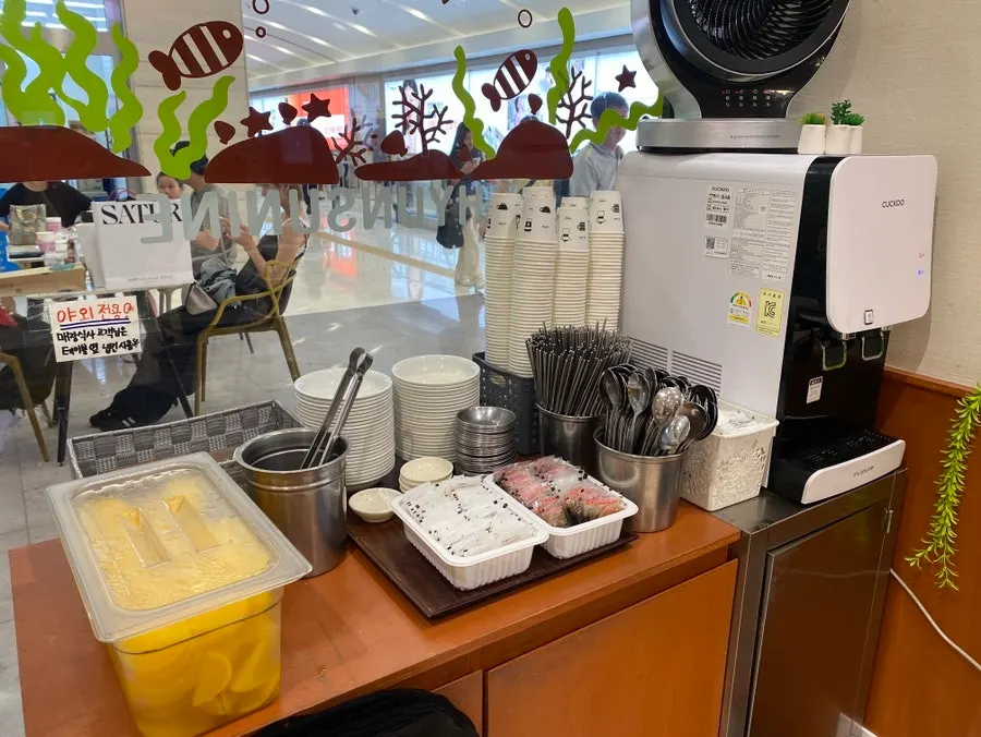 Self-serve bar stocked with water, cutlery, and pickled radish