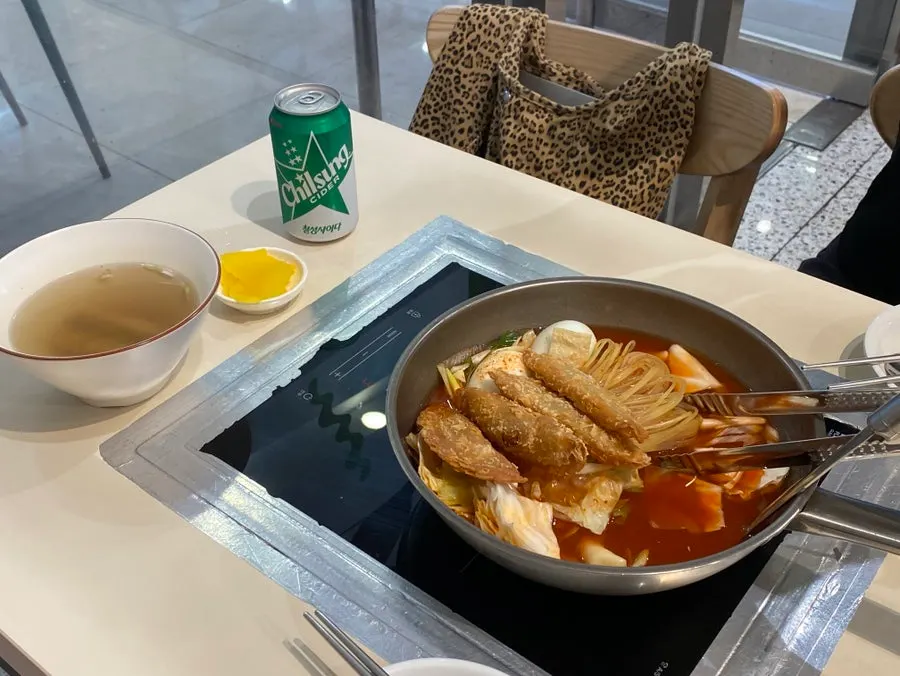 Pot of instant tteokbokki with rice cakes, dumplings, jjolmyeon, egg, and cabbage