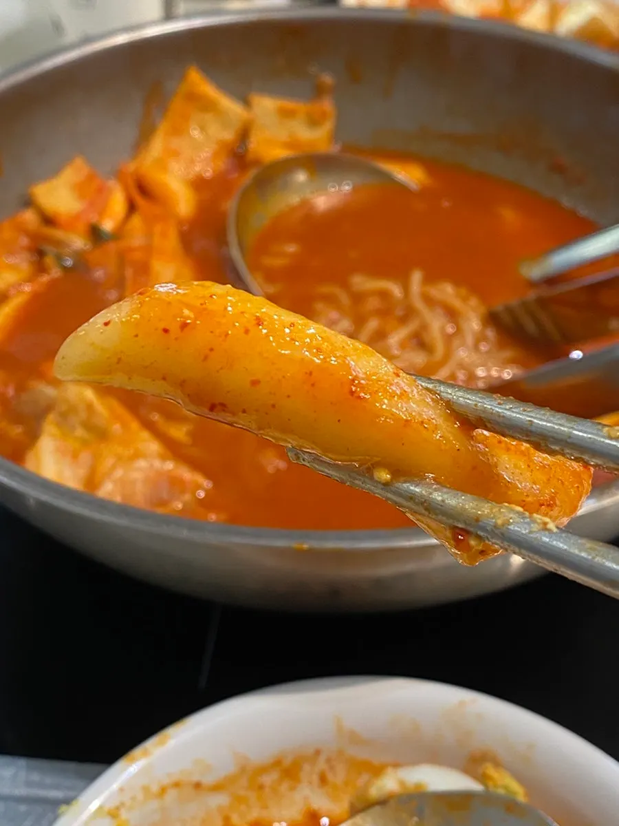 A sauce-soaked piece of Hyeonseonine's wheat rice cake