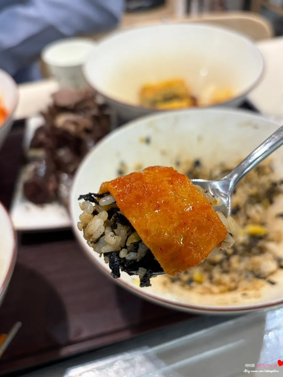 매운 양념에 버무려진 떡볶이 떡을 집어 든 모습