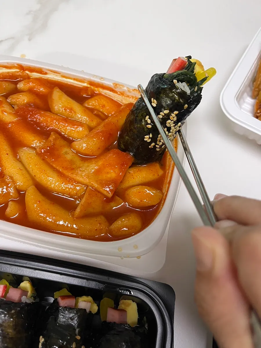 매운 떡볶이 한 입 집어 든 모습