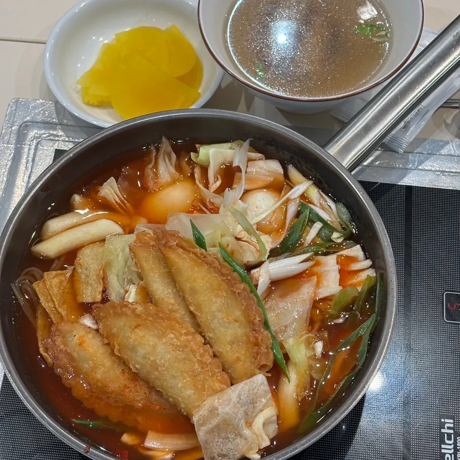 Table with instant tteokbokki, bong-eomuk, and cola