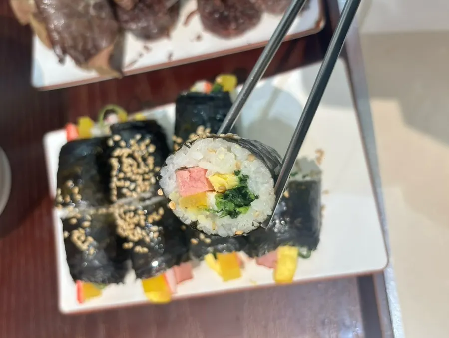 Plate of gimbap topped with sesame seeds