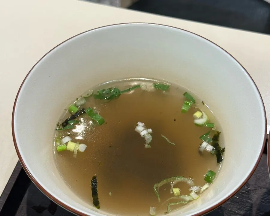 Rice ball topped generously with seaweed flakes alongside tteokbokki
