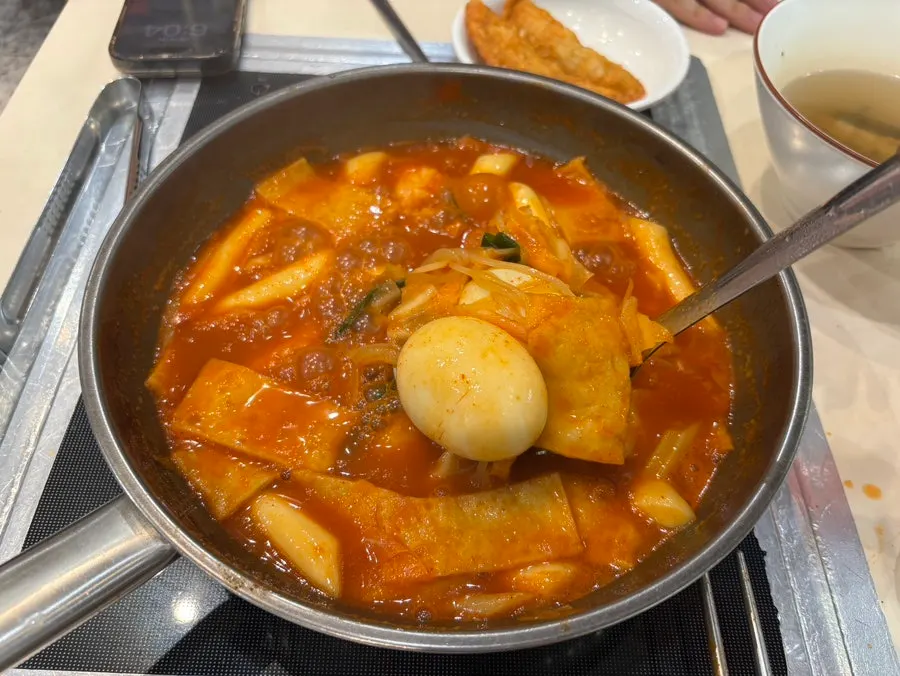 A spread of instant tteokbokki with side snacks