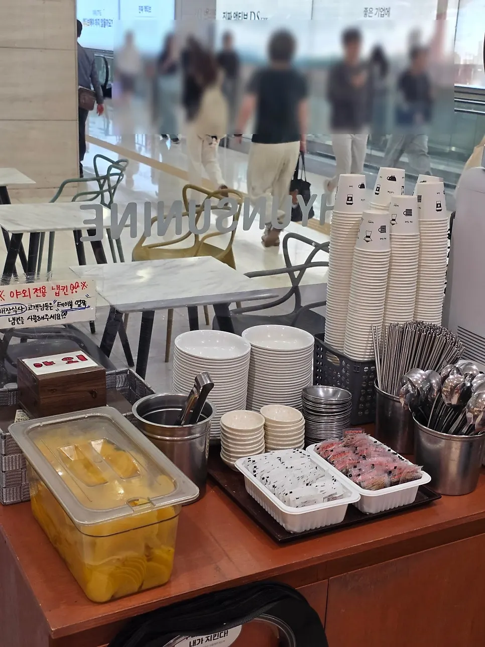 Self-serve bar with side dishes, cutlery, and water