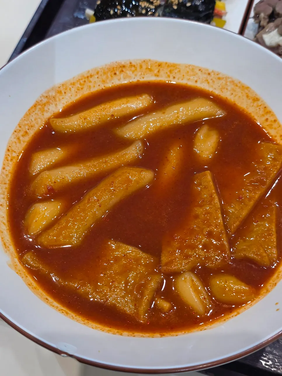 Close-up of broth tteokbokki with rice cake and fish cake