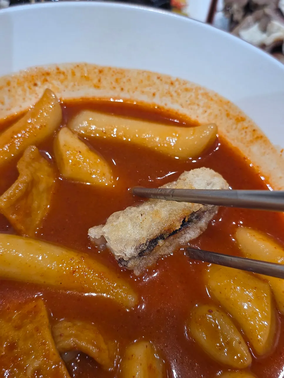 Fried snack dipped in tteokbokki sauce
