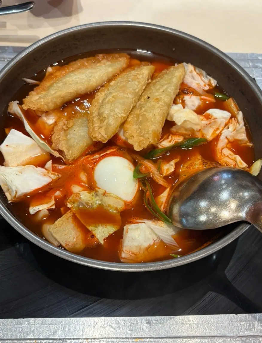 A pan of instant tteokbokki served with the raw ingredients still laid out